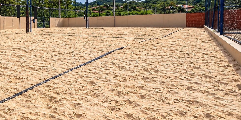 Quadra de areia vazia, com os refletores e o alambrado azul
