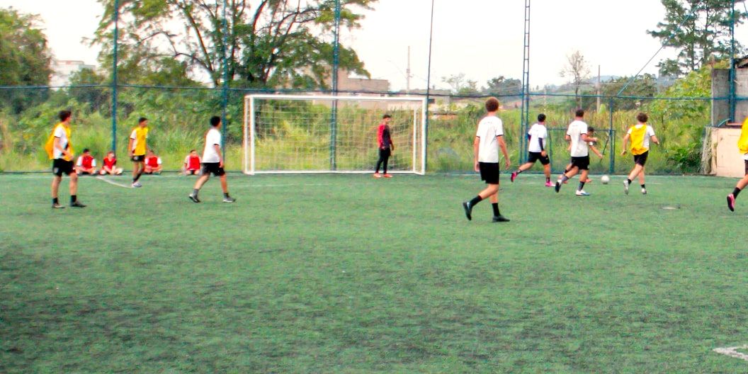 Jogo na quadra society, com o gol ao fundo